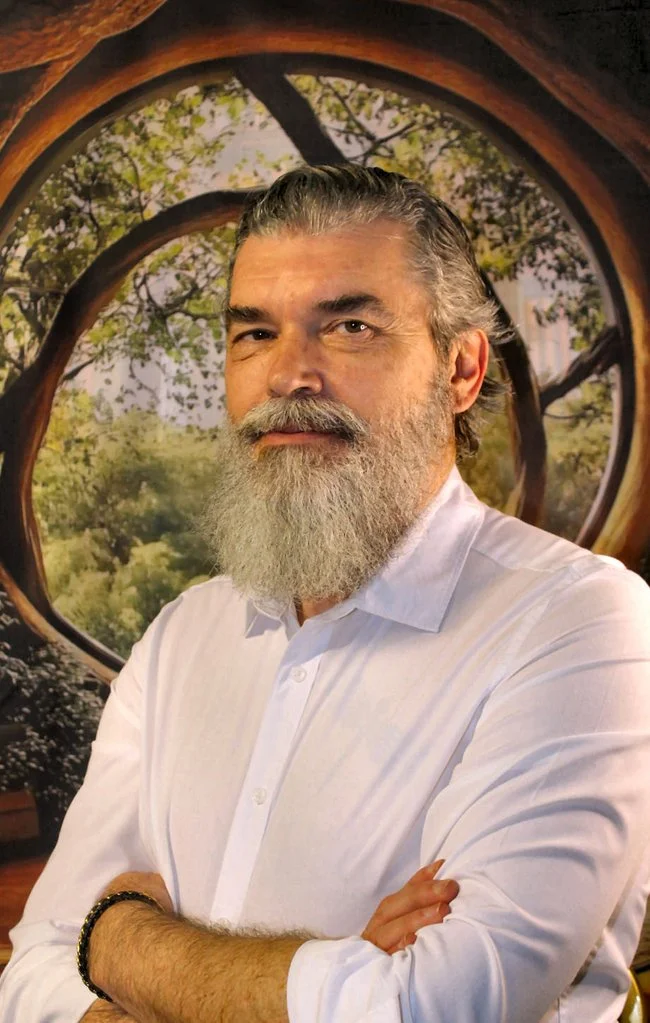 Siniša Crljen, prekriženih ruku, ispred okruglog prozora s pogledom na drveće